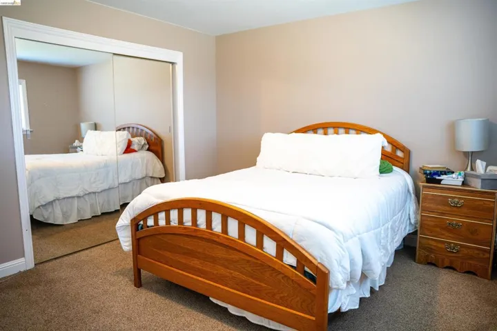 Bedroom featuring warm neutral wall tones and plush carpet flooring