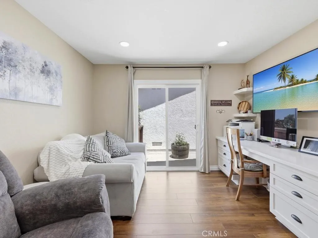 Secondary bedroom used as den with desk built-in and sliding door to side patio