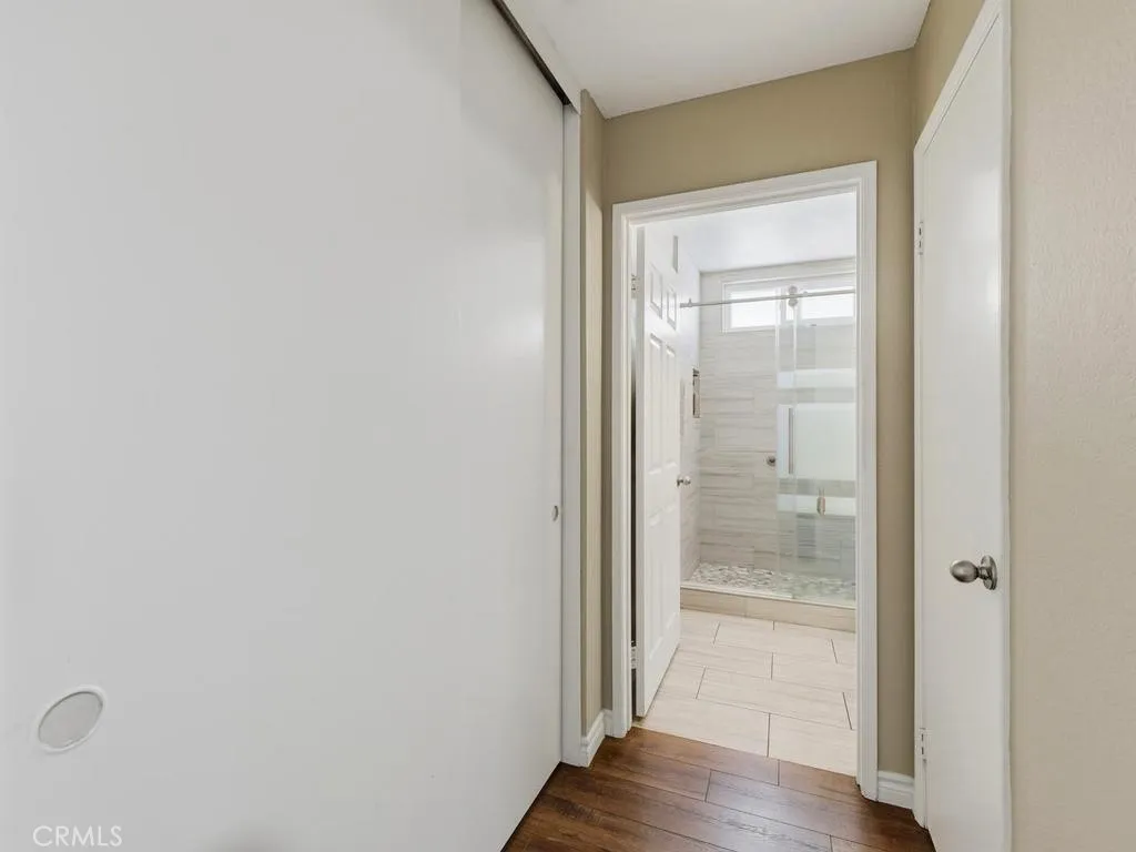 Storage closet in hallway and entry to secondary bathroom