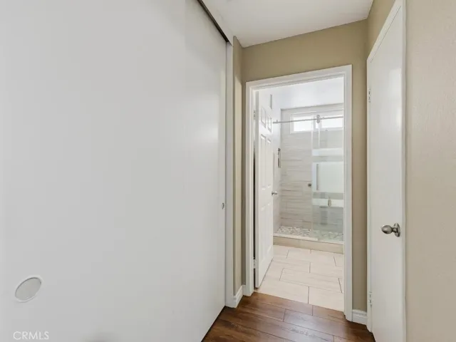 Storage closet in hallway and entry to secondary bathroom