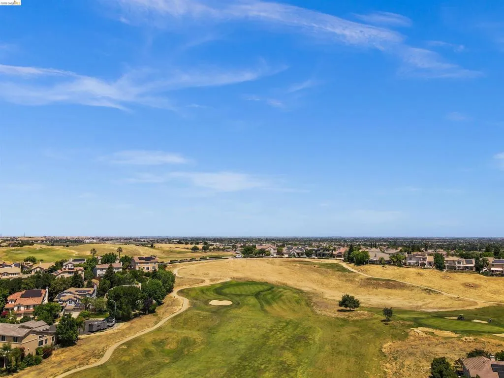 Aerial perspective showcasing a residential community bordering a golf course