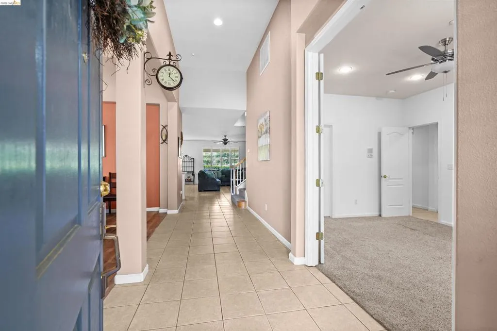 Entryway featuring tile flooring, vaulted ceilings, and a light color palette