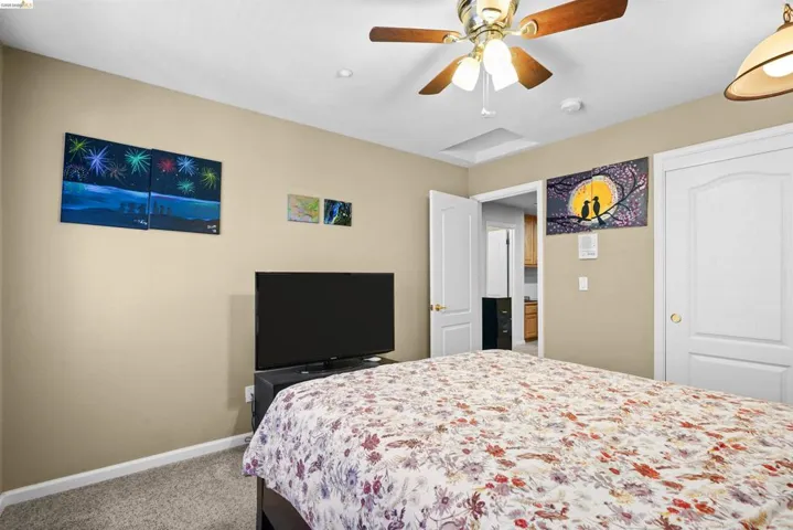 Neutral wall color, ceiling fan with wood-finish blades, recessed lighting, carpeted flooring, and white paneled doors