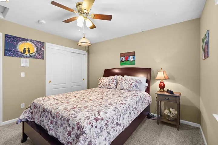 Carpeted room featuring a ceiling fan with light fixture, recessed lighting, and a closet with bi-fold doors