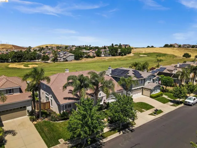 Aerial overview showcasing multiple homes with tile roofs and solar panels