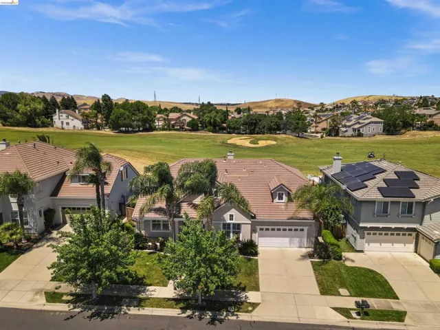 Residence with a two-car garage, mature front yard trees, and a terracotta-style roof