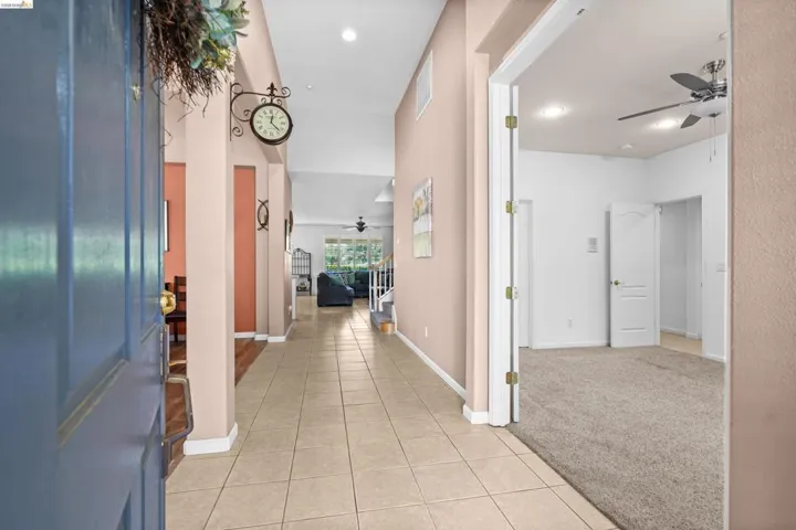 Entryway featuring tile flooring, vaulted ceilings, and a light color palette