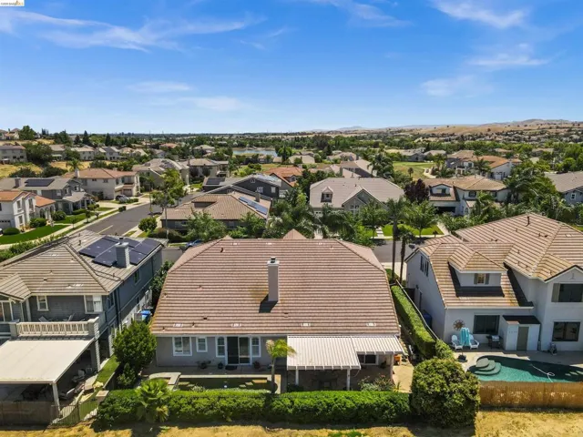 Residential property with a tile roof and a backyard featuring a swimming pool