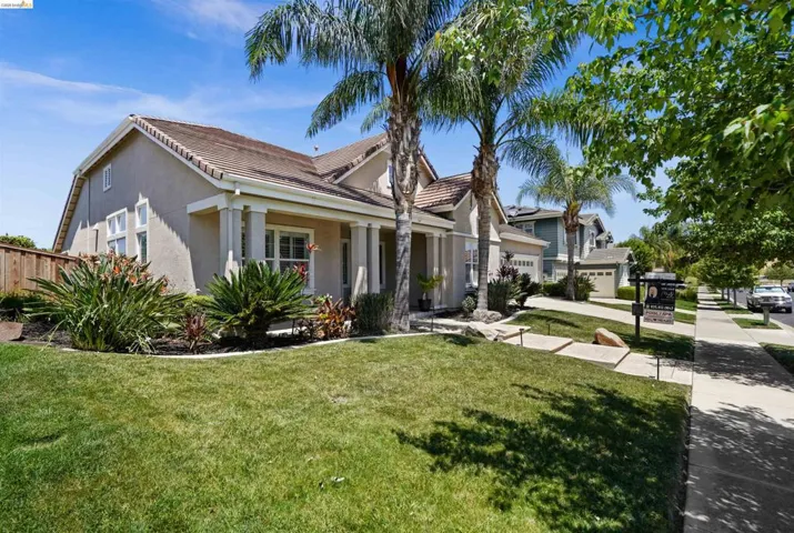 Stucco exterior featuring a tiled roof and covered front porch with columns