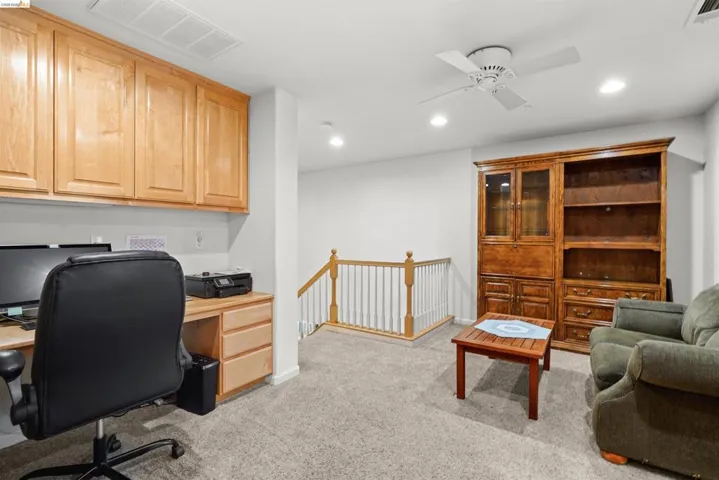 Integrated desk area featuring built-in wood cabinetry and a wood-finish countertop