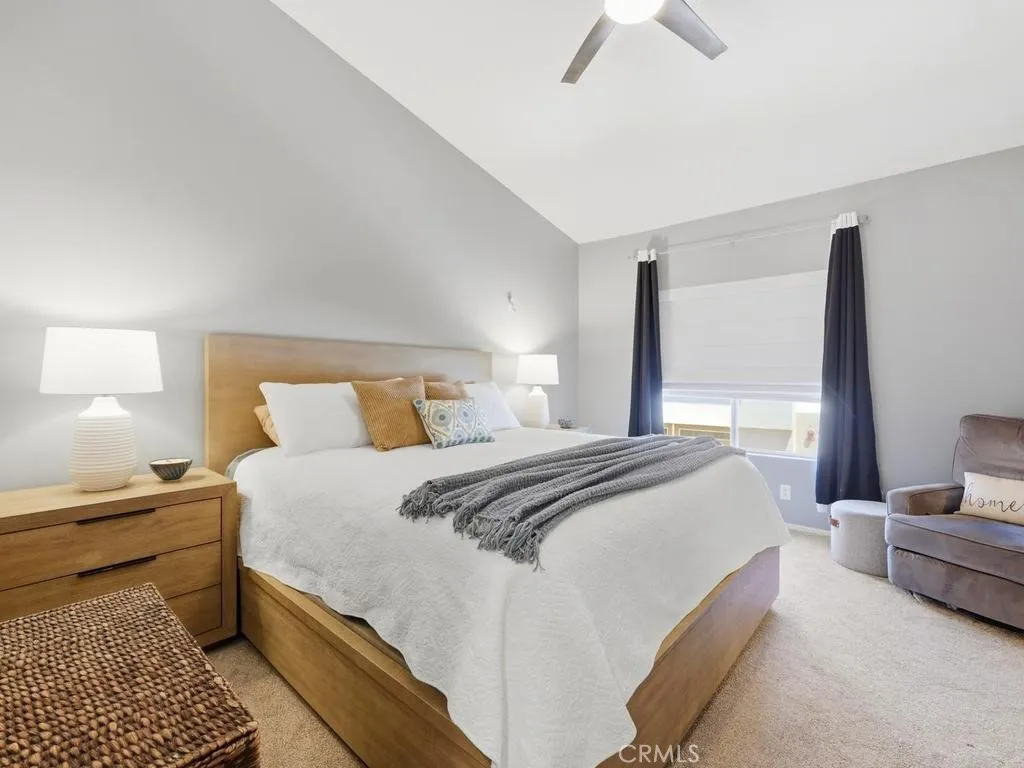 Primary bedroom with sloped, high ceilings and ceiling fan