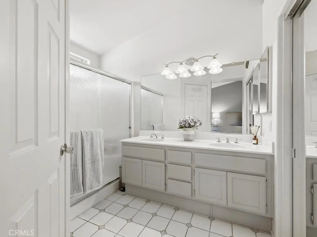 Primary bathroom with dual sinks and storage