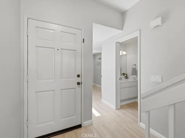 Entryway with view to stairs, downstairs' powder room and laundry down the hall