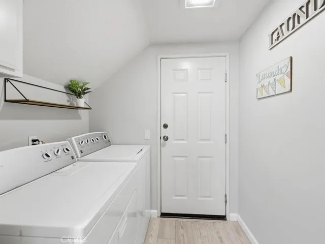 Laundry room downstairs with door to attached one car garage