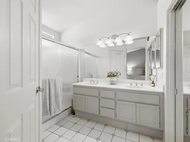 Primary bathroom with dual sinks and storage