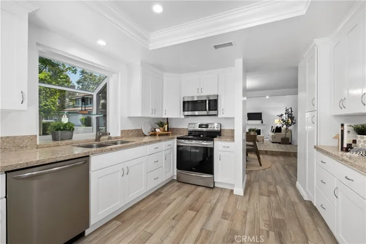 Kitchen features stone counter tops and stainless appliances