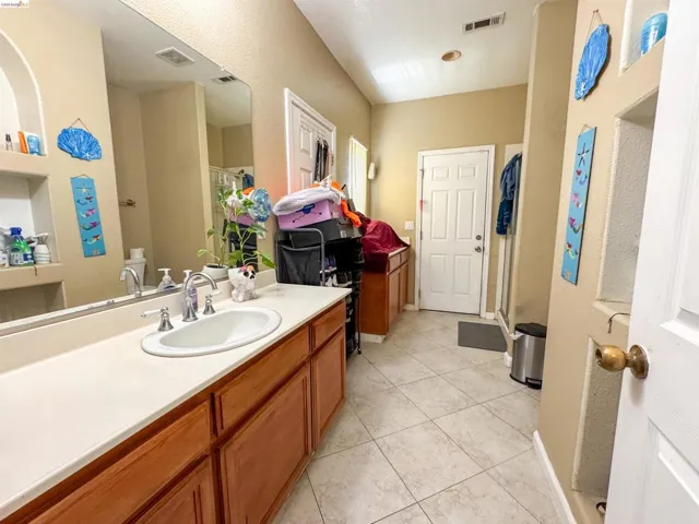 Vanity featuring an integrated sink, cream-colored countertop, and wood-finish cabinetry