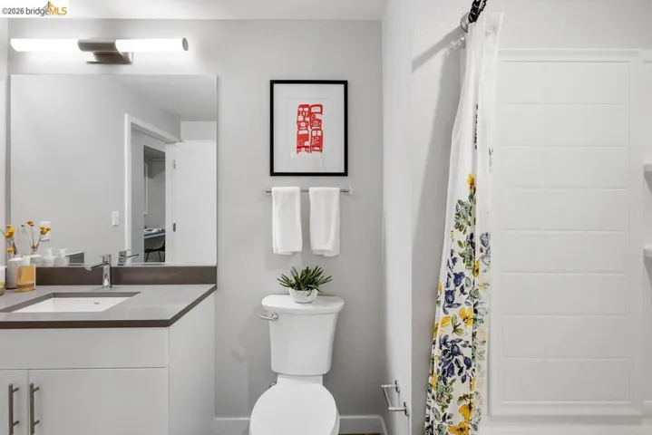Bathroom featuring a white vanity with brushed nickel hardware, a neutral countertop, and an integrated rectangular sink