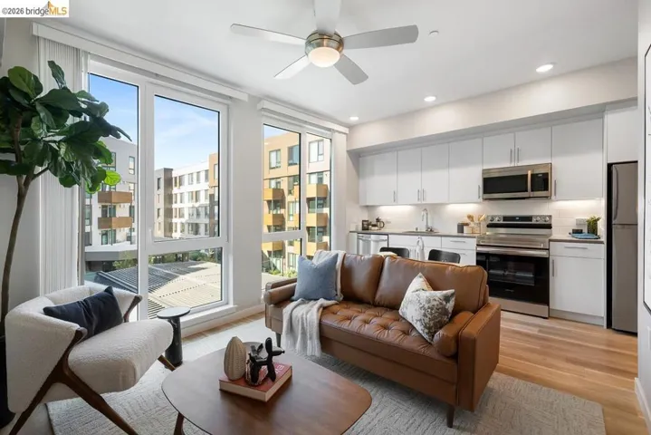 Open-concept living area featuring wood-finish flooring, a contemporary ceiling fan, and recessed lighting