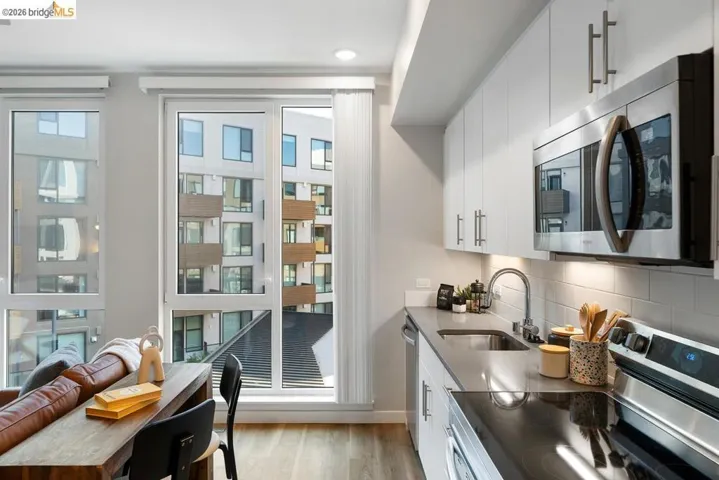 Modern kitchen featuring white flat-panel cabinetry, stainless steel appliances, and a gray countertop