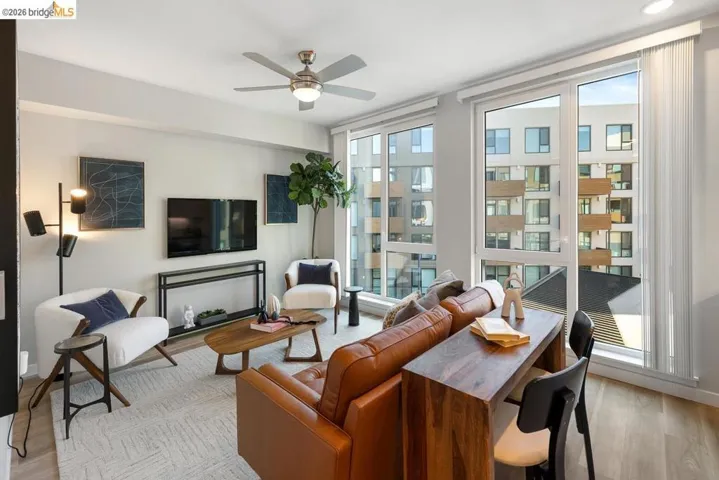 Living area featuring floor-to-ceiling windows, wood-finish flooring, and a ceiling fan