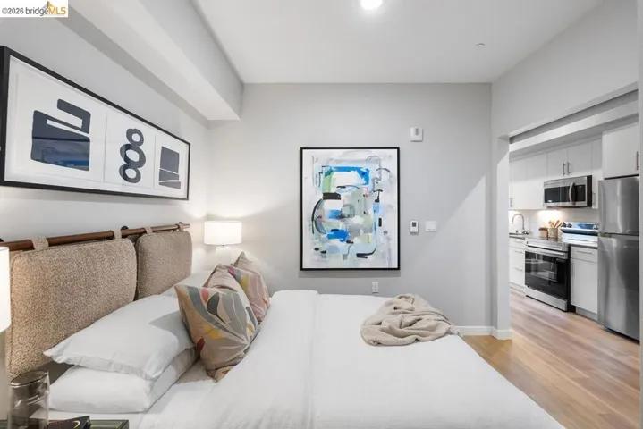 Bedroom space featuring light gray walls, recessed lighting, and a beige upholstered headboard