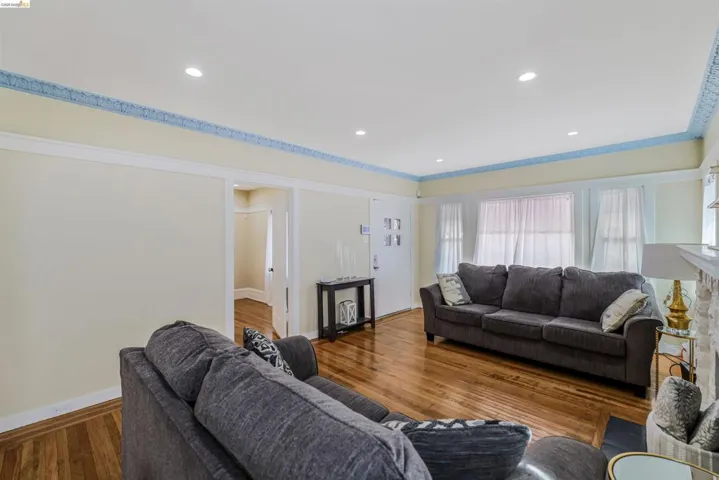 Living room with wood finished floors, recessed lighting, and a fireplace