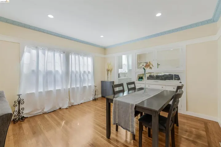 Dining area with wood finished floors, recessed lighting, and ornamental molding