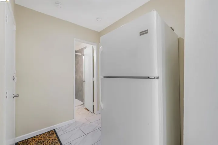 Corridor with baseboards and light marble finish floors