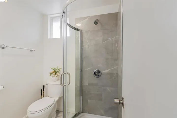 Bathroom featuring a shower stall and tile patterned flooring