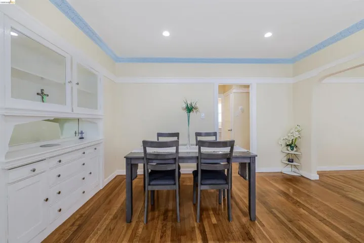 Dining room featuring dark wood-type flooring, recessed lighting, arched walkways, and crown molding