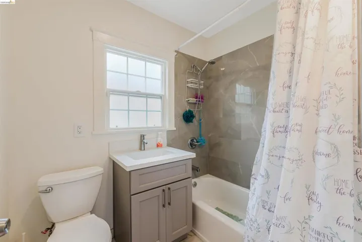Full bath with shower / bath combination with curtain and vanity