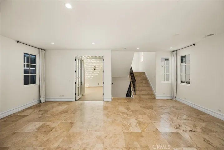 The second level serves as the main living space and features an inviting living room, dining area, and kitchen filled with natural light and ocean breezes.
