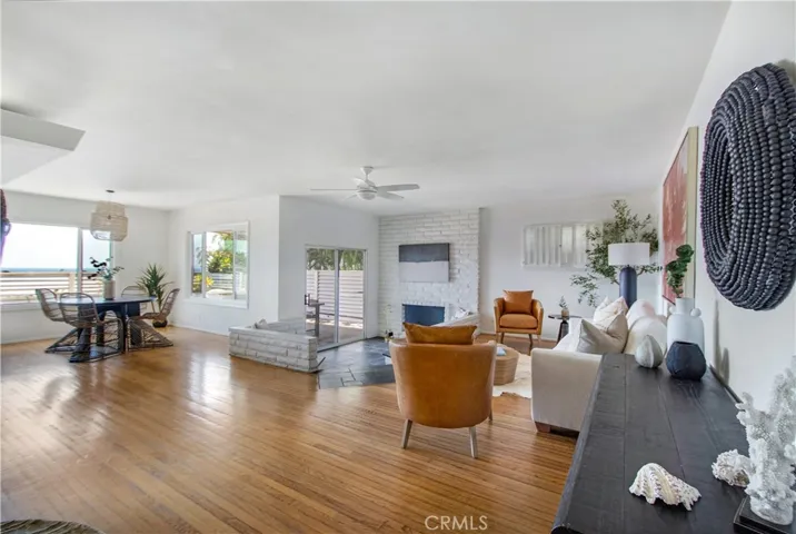 View of dining area, fireplace sitting are, slider to back side covered patio and living room.