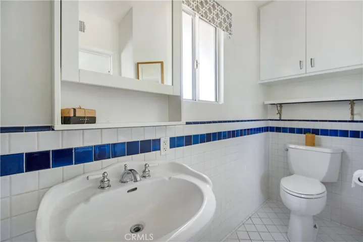 Primary ensuite bathroom pedestal sink and toilet.