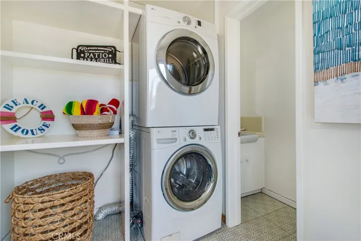 Off of kitchen is laundry room with stackable washer and dryer and adjacent is half bathroom entry.