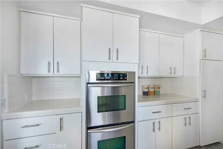 Kitchen with dual ovens and plenty of cabinets and drawers for storage.