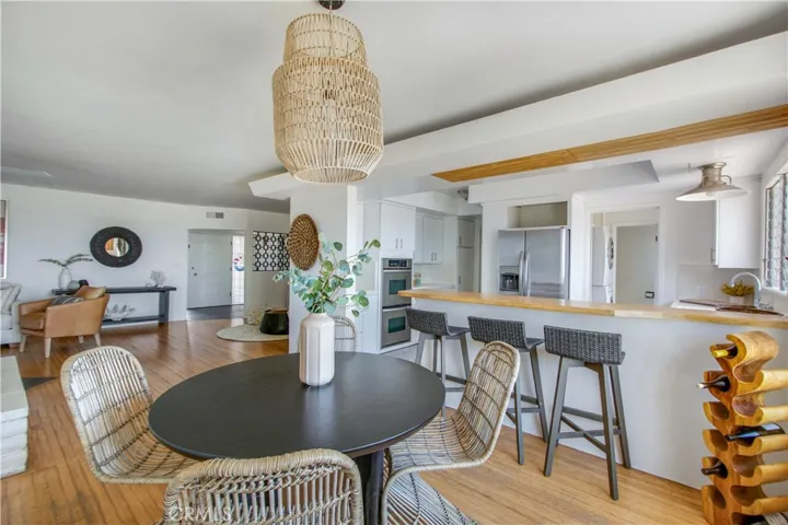 View from dining area into kitchen, living room, sitting area and main entry.