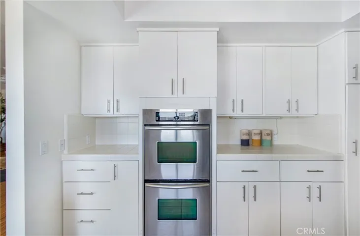 Another view of Kktchen with dual ovens and plenty of cabinets and drawers for storage.