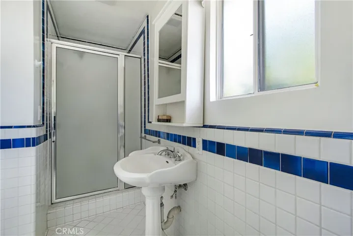Primary ensuite bathroom pedestal sink and walk-in-shower.