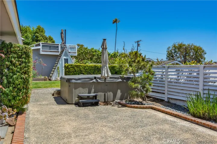 Back yard view of jacuzzi and cottage.