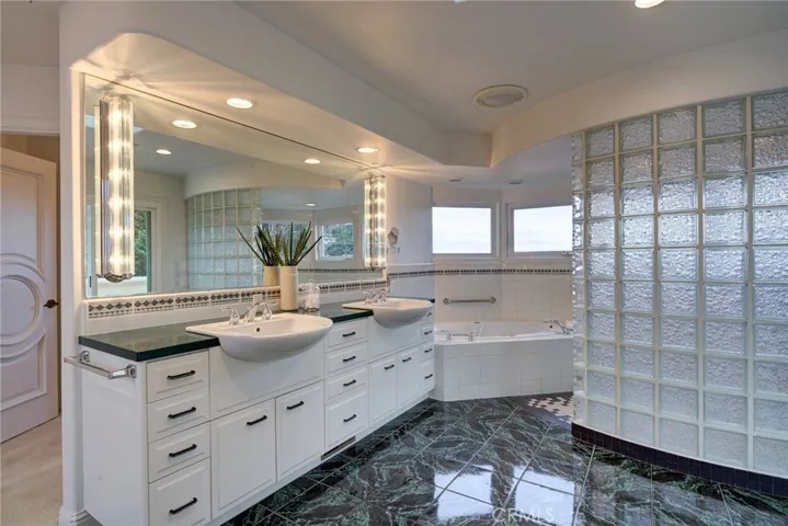 primary bathroom two sink walk in shower and soaking jet tub