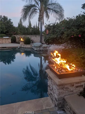 Night View Of Pool With Fire Bowls