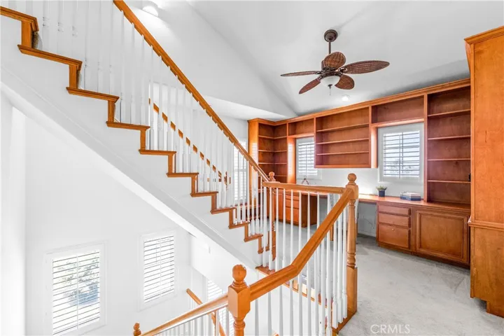 A stunning light -filled mezzanine retreat awaits at the top of t he stairs, featuring a wall-to-wall custom library office with wrap around built-ins, and an elevated loft space perfect for a studio, reading nook, gym or 5th bedroom.