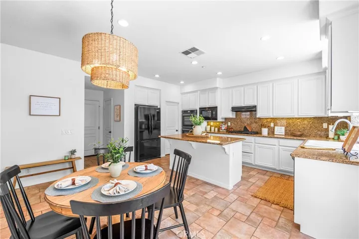 Spacious and beautifully connected to the living areas, the kitchen features a generous breakfast nook, center island with seating and storage, abundant cabinetry, walk -in pantry, and sunlit backyard views.