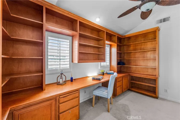 A stunning light -filled mezzanine retreat awaits at the top of t he stairs, featuring a wall-to-wall custom library office with wrap around built-ins, and an elevated loft space perfect for a studio, reading nook, gym or 5th bedroom.