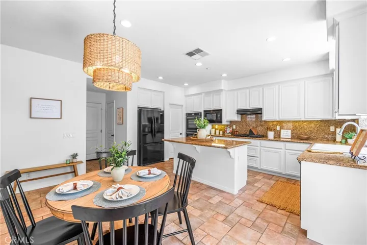Spacious and beautifully connected to the living areas, the kitchen features a generous breakfast nook, center island with seating and storage, abundant cabinetry, walk -in pantry, and sunlit backyard views.