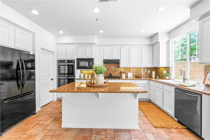 Spacious and beautifully connected to the living areas, the kitchen features a generous breakfast nook, center island with seating and storage, abundant cabinetry, walk -in pantry, and sunlit backyard views.