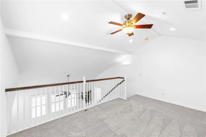 The expansive primary suite offers soaring ceilings, dramatic wall-to-wall windows, a unique upper loft retreat, spa-inspired bath with soaking tub, dual vanities, a linen closet, and a walk-in closet.