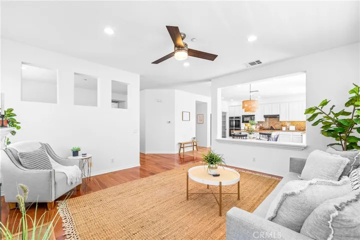 Designed for seamless everyday living and entertaining, the expansive great room flows effortlessly into the kitchen, dining, and breakfast areas with rich wood floors, recessed lighting, a cozy fireplace, and wall-to-wall windows.